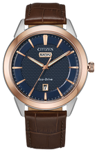 Load image into Gallery viewer, Gents Citizen Watch AW0096-06L. This Corso model is shown in a two-tone rose gold-tone and white stainless steel case, brown leather band, and a navy blue dial with a day and date window. Features include: Eco-Drive technology, sapphire crystal, and water resistance up to 100 meters.