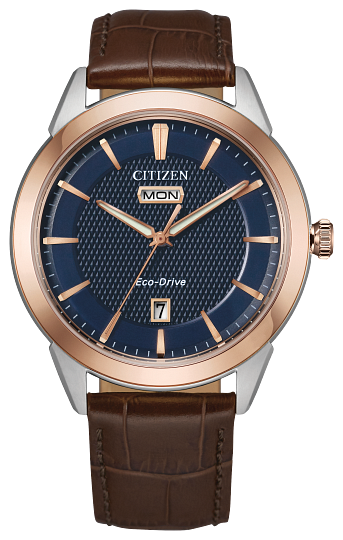 Gents Citizen Watch AW0096-06L. This Corso model is shown in a two-tone rose gold-tone and white stainless steel case, brown leather band, and a navy blue dial with a day and date window. Features include: Eco-Drive technology, sapphire crystal, and water resistance up to 100 meters. 