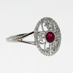  14 karat white gold ruby and diamond oval filigree ring containing one 0.36ct round ruby and 0.17cttw round diamonds.